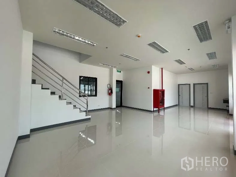 โรงงาน for rent in Bang Sao Thong, Samut Prakan - พื้นที่สำนักงานชั้นล่างพร้อมบันได ตู้สายฉีดน้ำดับเพลิง และประตูหลายบาน