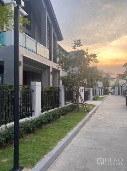 Detached House for rent in Lak Si, Bangkok - Tree-lined residential street with contemporary homes, front fences and sunset sky.