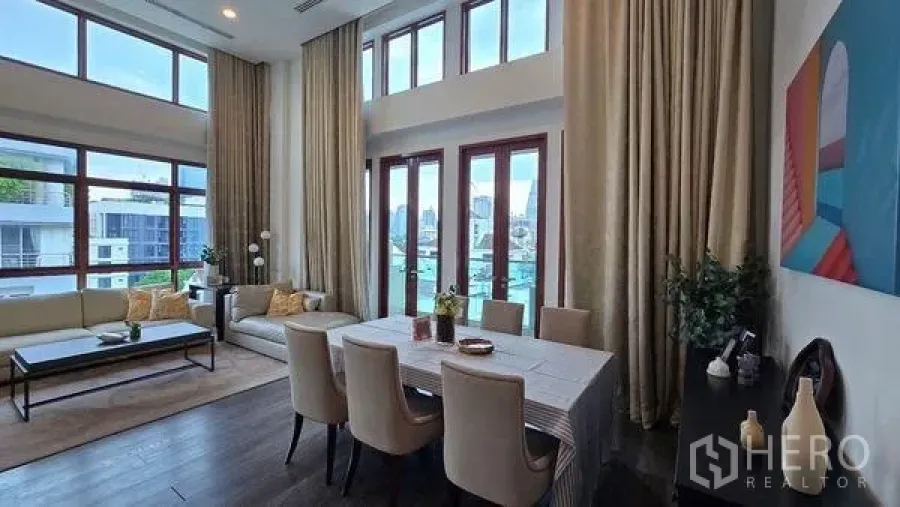 คอนโด ให้เช่าในPathum Wan, Bangkok - มุมมองอีกด้านของโซนรับแขก–ทานข้าวเพดานสูง พร้อมผ้าม่านและหน้าต่างสูง