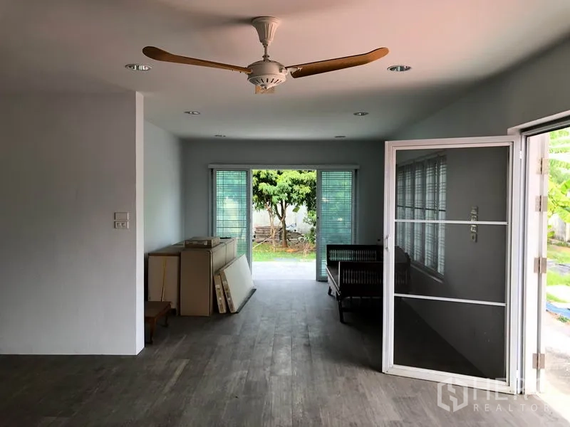 独立式住宅 出售在Bang Khen, Bangkok - 起居与餐厅空间，纱门与吊扇，视野通向后园及侧房。