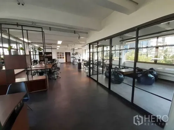 Office Space for rent in Khlong Toei, Bangkok - Corridor of an office with glass-walled meeting room and beanbag lounge, flooded with daylight.