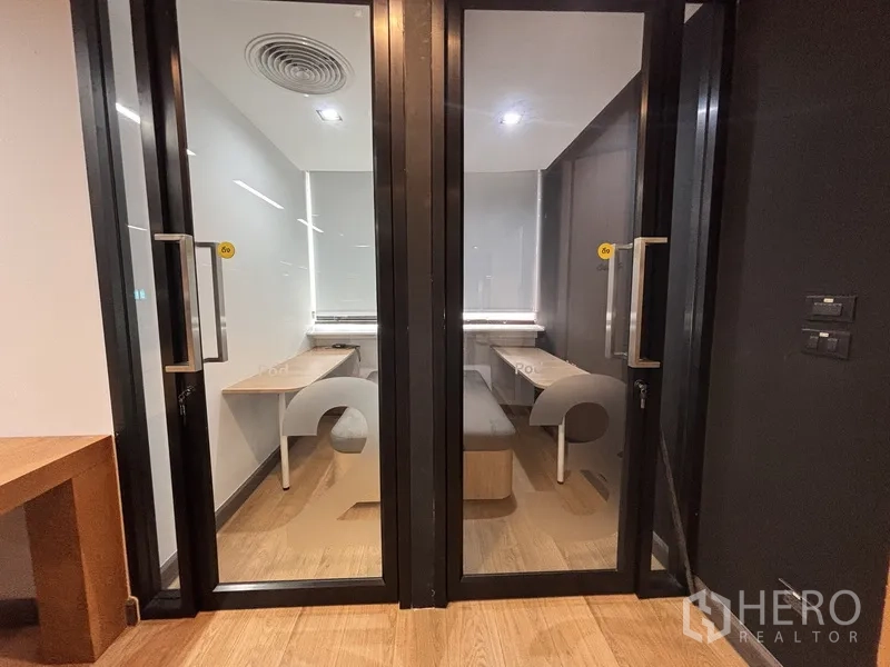 办公室 for rent in Bang Rak, Bangkok - 两间私密电话间，内设内置书桌与长椅，玻璃门相对。