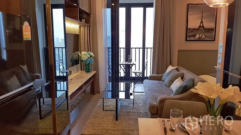 คอนโด ให้เช่าในWatthana, Bangkok - ห้องนั่งเล่นพร้อมชั้นวางทีวี โต๊ะกาแฟกระจก และระเบียงนั่งชมวิวเมือง