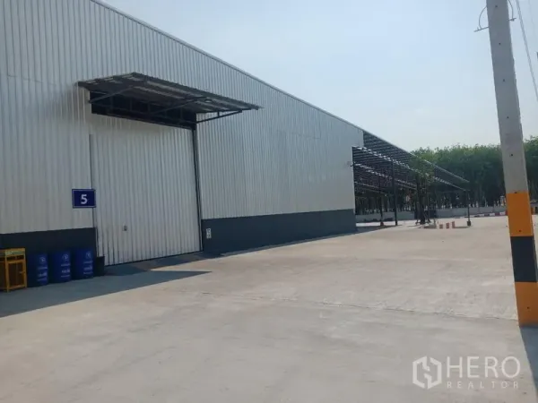 คลังสินค้า ให้เช่าในPluak Daeng, Rayong - ด้านหน้าโกดัง ประตูบานเลื่อนขนาดใหญ่ มีกันสาดและทางรถบรรทุก