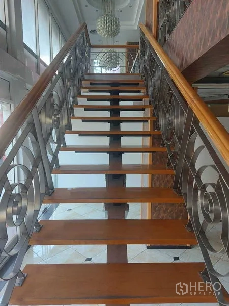 零售空间 出租在Pathum Wan, Bangkok - 木质踏板配金属栏杆的楼梯，上方悬挂吊灯。