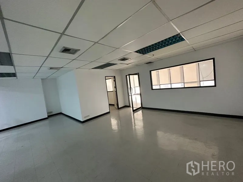 Office Space for rent in Ratchathewi, Bangkok - Open-plan office area with suspended ceiling, air vents, internal glass door and a partitioned meeting room.