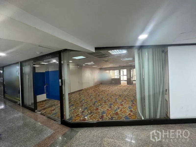 สำนักงาน ให้เช่า - ยูนิตออฟฟิศกระจกเต็มบาน แสงสว่าง เพดานไฟ และพรมลาย มองจากโถงทางเดิน