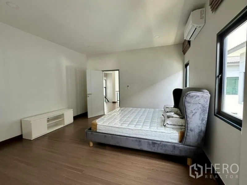 独立式住宅 出租在Bang Phli, Samut Prakan - 次卧配软包床、窗户与壁挂空调。