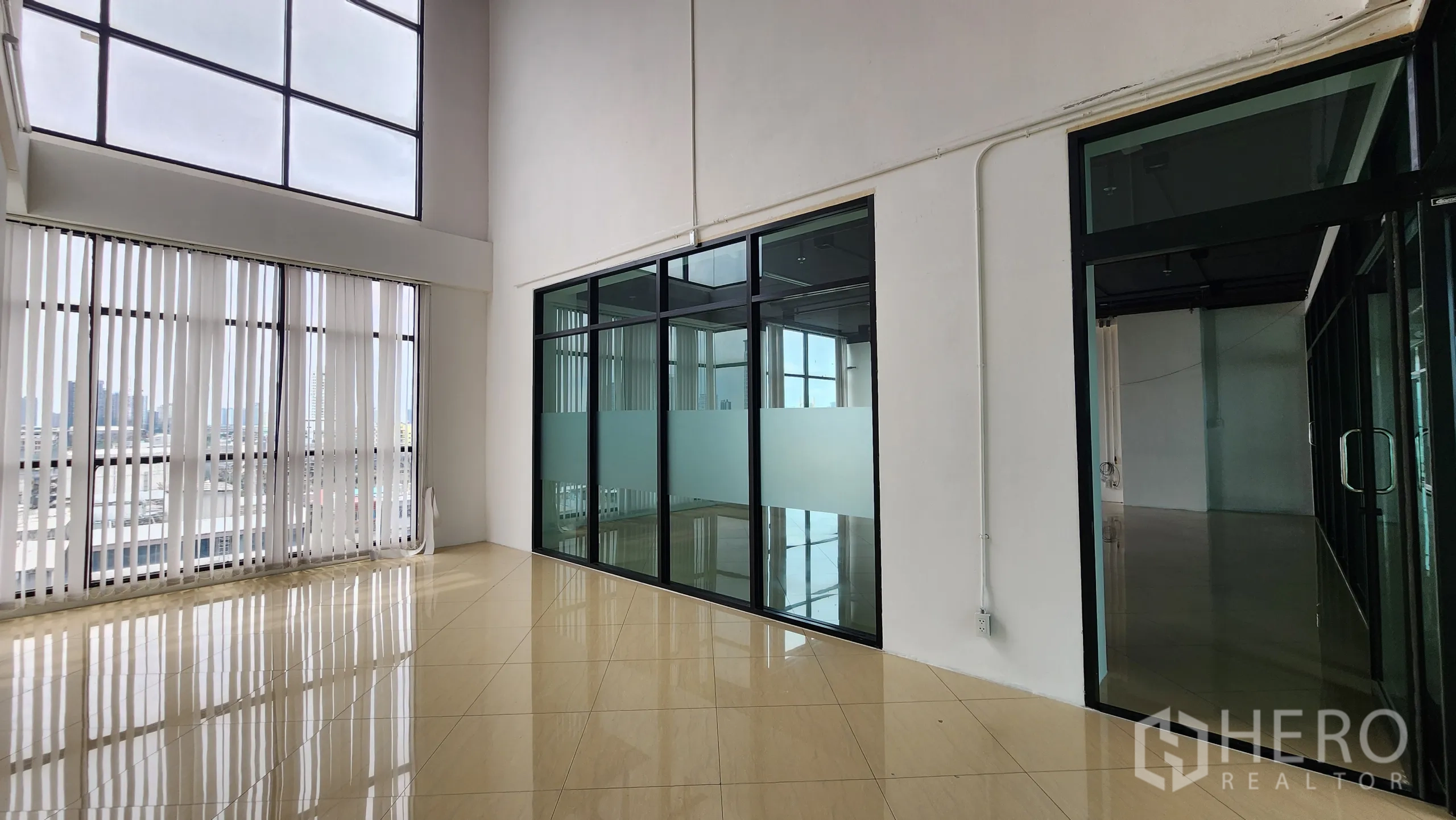 Office Space for rent in Yan Nawa, Bangkok - Bright nook with vertical blinds next to black-framed glass partitions.