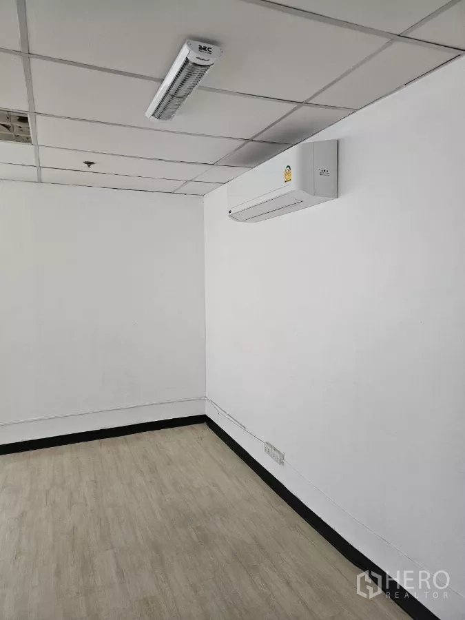 办公空间 出租在Watthana, Bangkok - 小型办公室内的壁挂分体空调，LED灯与复合木地板。