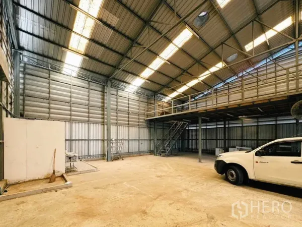 Warehouse for rent in Din Daeng, Bangkok - Open floor space with steel mezzanine and staircase for extra storage.
