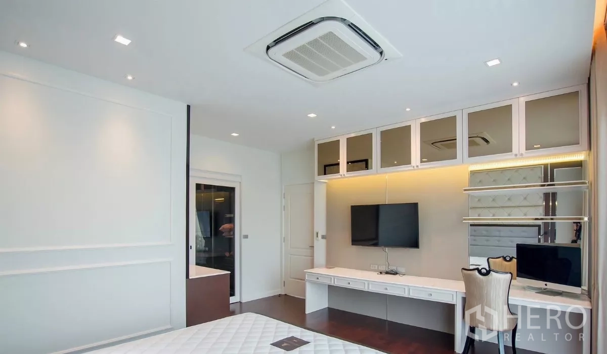 Detached House for rent in Bang Bon, Bangkok - Bedroom workspace with built-in desk, wall cabinets and mounted television.