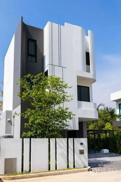 บ้าน ให้เช่าหรือขายในLat Krabang, Bangkok - มุมมองภายนอกอีกด้านของบ้าน 3 ชั้น พร้อมรั้วและที่จอดรถ