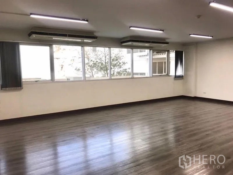 Office Space for rent in Bangkok Noi, Bangkok - Window‑lined office with two ceiling air conditioners and leafy city outlook.