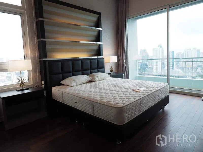 Condominium for rent in Ratchathewi, Bangkok - Master bedroom with floor-to-ceiling windows, balcony access and panoramic Bangkok skyline.