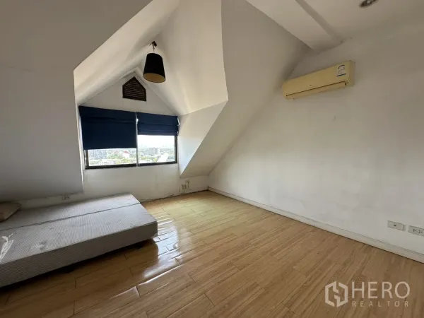 คอนโด ขายในBang Na, Bangkok - ห้องนอนเพดานลาด พื้นไม้ ม่านสีน้ำเงิน และเครื่องปรับอากาศติดผนัง