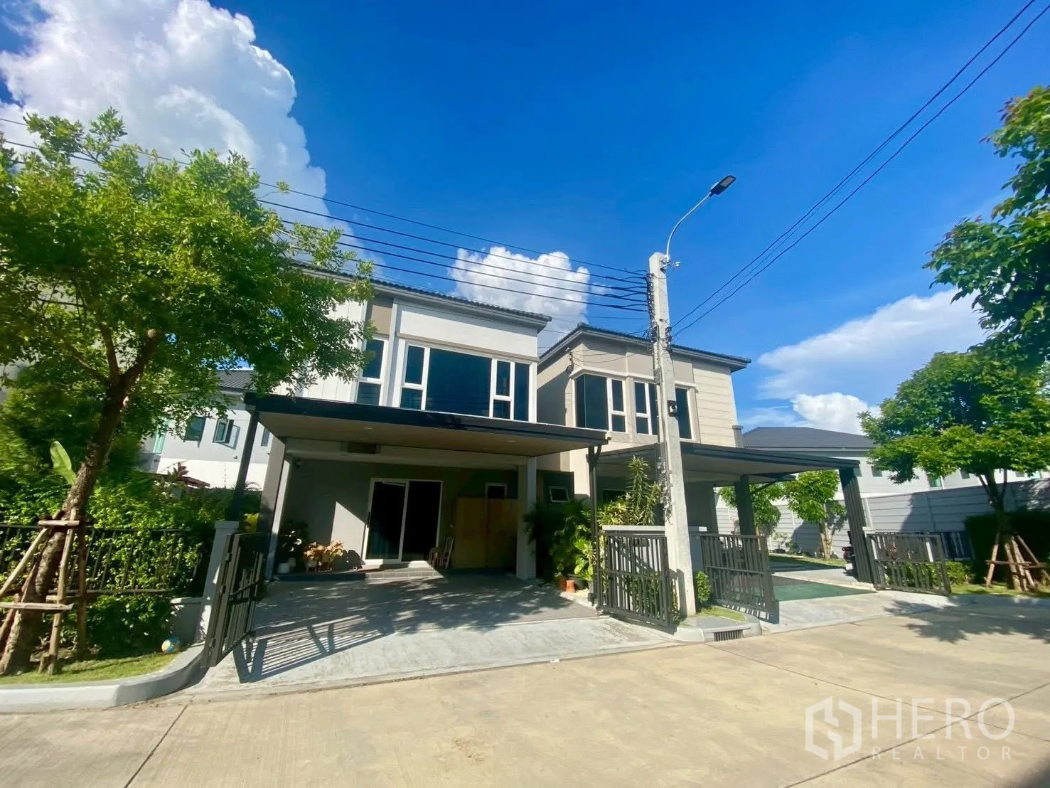 Semi-detached House for rent in Bang Phli, Samut Prakan - Street view of two-storey semi-detached homes with gated driveways.