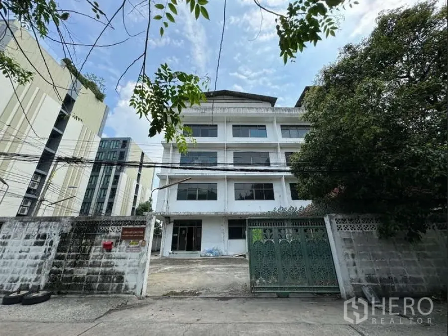 Home Office for sale in Bang Na, Bangkok - Front view of a five-storey home office/warehouse with gated entrance and driveway in Samut Prakan.