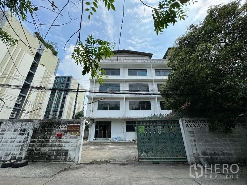 Home Office for sale in Bang Na, Bangkok - Front view of a five-storey home office/warehouse with gated entrance and driveway in Samut Prakan.