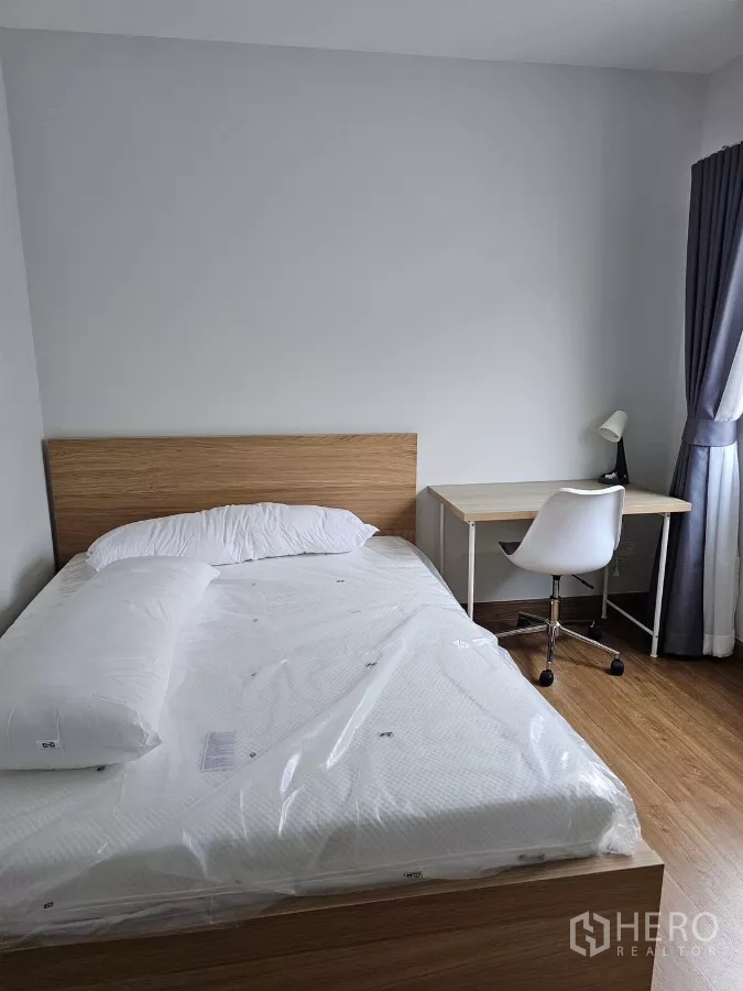 Detached House for rent in Bang Phli, Samut Prakan - Third bedroom with bed, study desk and chair with full-length curtains.