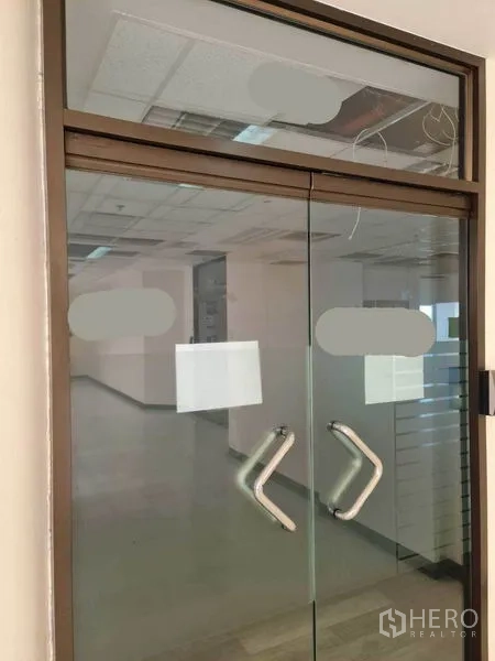 สำนักงาน ให้เช่าในWatthana, Bangkok - ประตูทางเข้ากระจกสองบานพร้อมมือจับโลหะและสติ๊กเกอร์ฝ้า