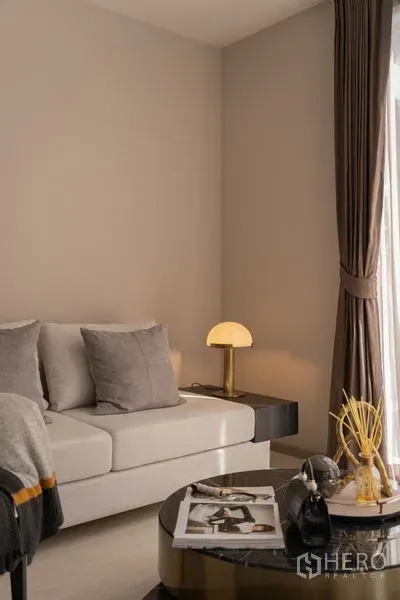 คอนโด ให้เช่าในWatthana, Bangkok - มุมโซฟาพร้อมโคมไฟตั้งโต๊ะและโต๊ะกลางกลมข้างหน้าต่าง