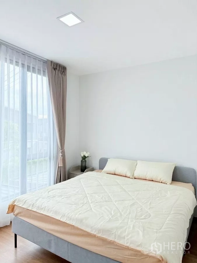 ทาวน์เฮาส์ ให้เช่าในBang Phli, Samut Prakan - ห้องนอนใหญ่เตียงคู่ชิดหน้าต่างเต็มความสูง พร้อมโต๊ะข้างเตียง