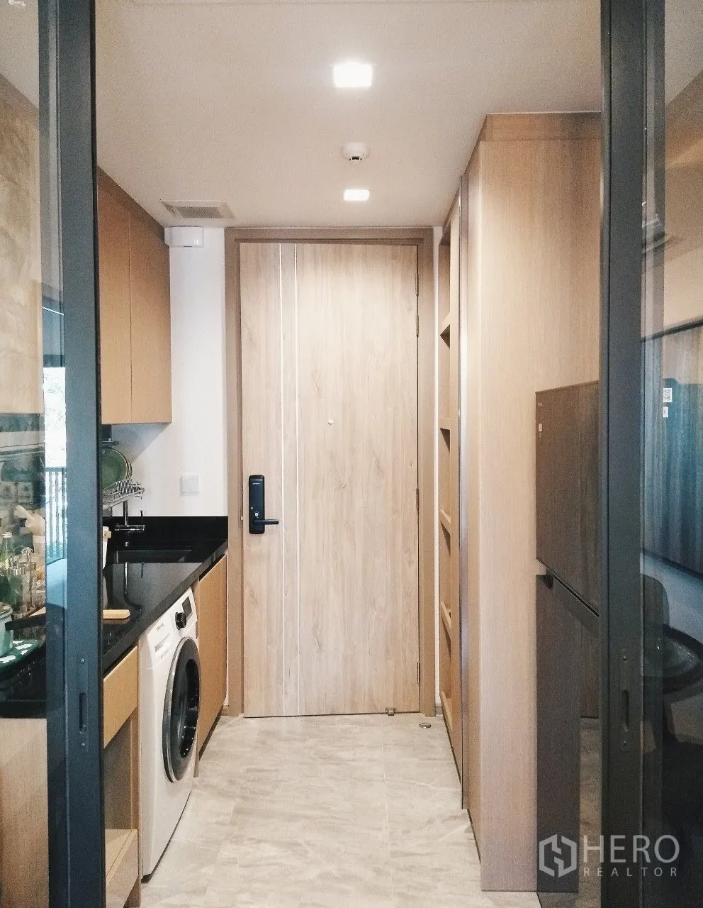 公寓 for rent in Watthana, Bangkok - 独立厨房走廊，黑色台面、洗衣机与木质橱柜。