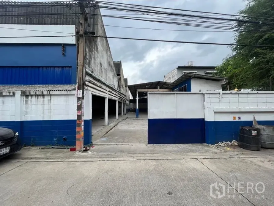 Warehouse for rent in Phra Khanong, Bangkok - Sliding gate entrance leading to central yard and covered bays.