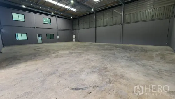 Factory for rent in Bang Bo, Samut Prakan - High-bay warehouse interior with polished concrete floor, skylights and side office windows.