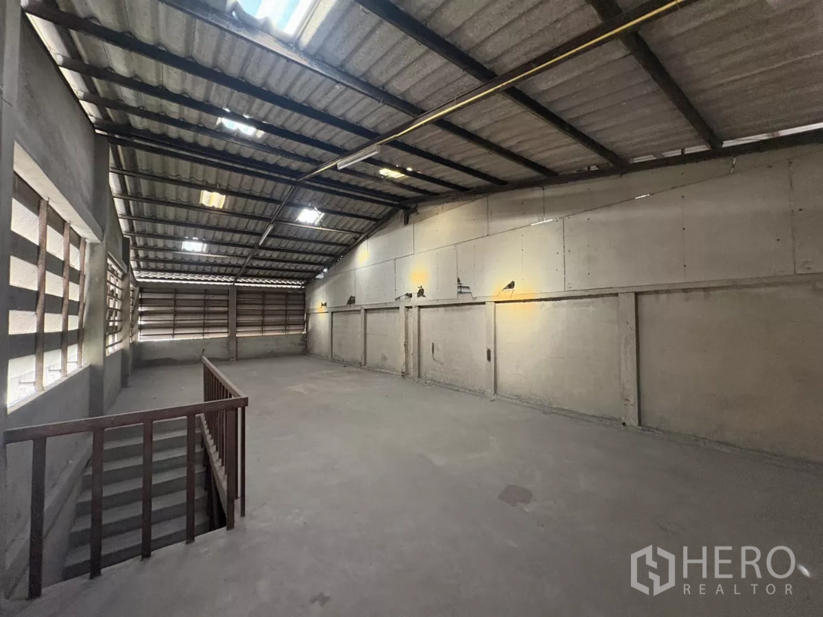 Warehouse for rent in Khlong Toei, Bangkok - Open mezzanine workspace beneath metal roofing with ample natural light.