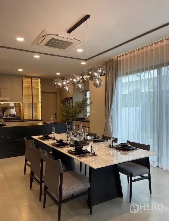 Detached House for rent in Bang Phli, Samut Prakan - Dining area with six-seat marble table and globe pendant lighting.