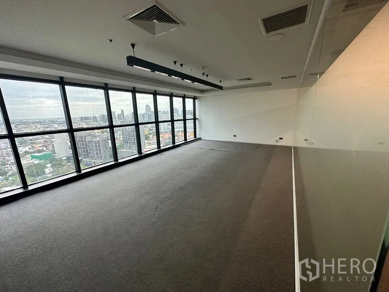 Office Space for rent - Long conference-ready room with wall of windows and skyline view.