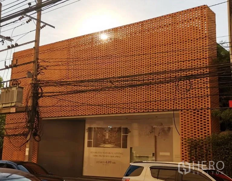 零售空间 出租在Khlong Toei, Bangkok - 街景：两层零售展厅，陶土色穿孔砖立面与大型展示橱窗。