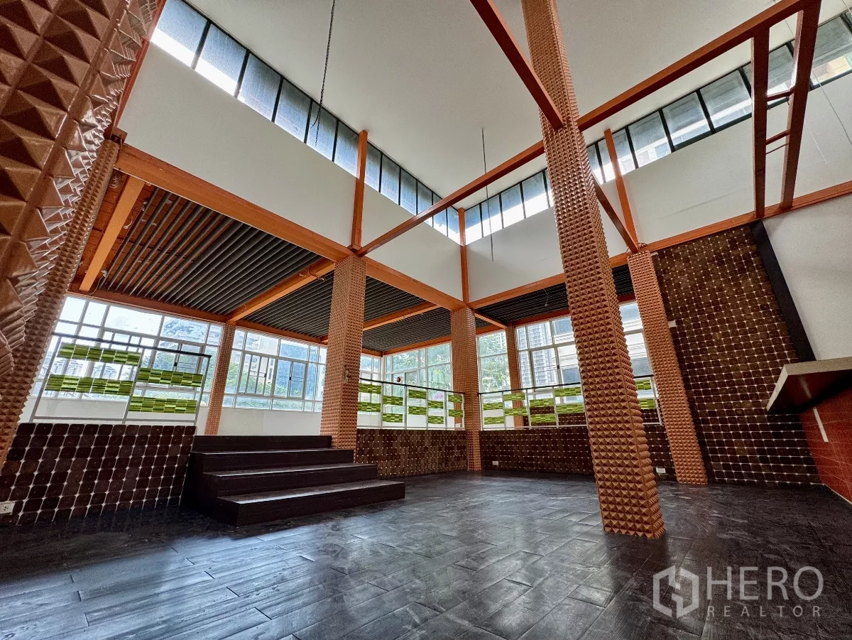 Shophouse for rent in Sathon, Bangkok - Spacious double-height area with platform steps and clerestory windows.