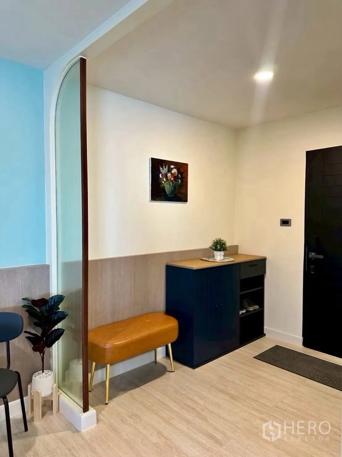 Condominium for rent in Huai Khwang, Bangkok - Entry foyer with shoe cabinet, bench, and decorative screen.