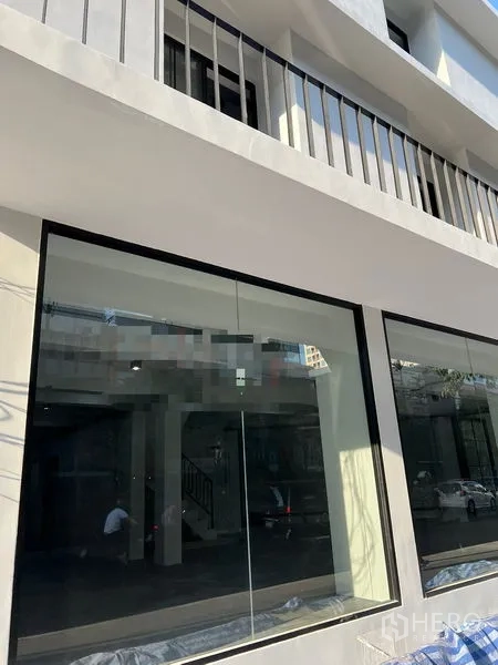 อาคารพาณิชย์ ให้เช่าในKhlong Toei, Bangkok - ภาพระยะใกล้ของกระจกหน้าร้านชั้นล่างและราวระเบียงชั้นบนของอาคารพาณิชย์.