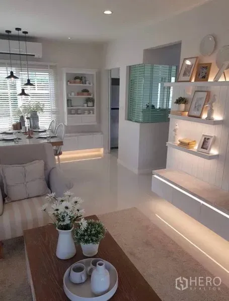 Detached House for rent in Bang Bo, Samut Prakan - Contemporary living area with illuminated wall shelves and a dining nook.