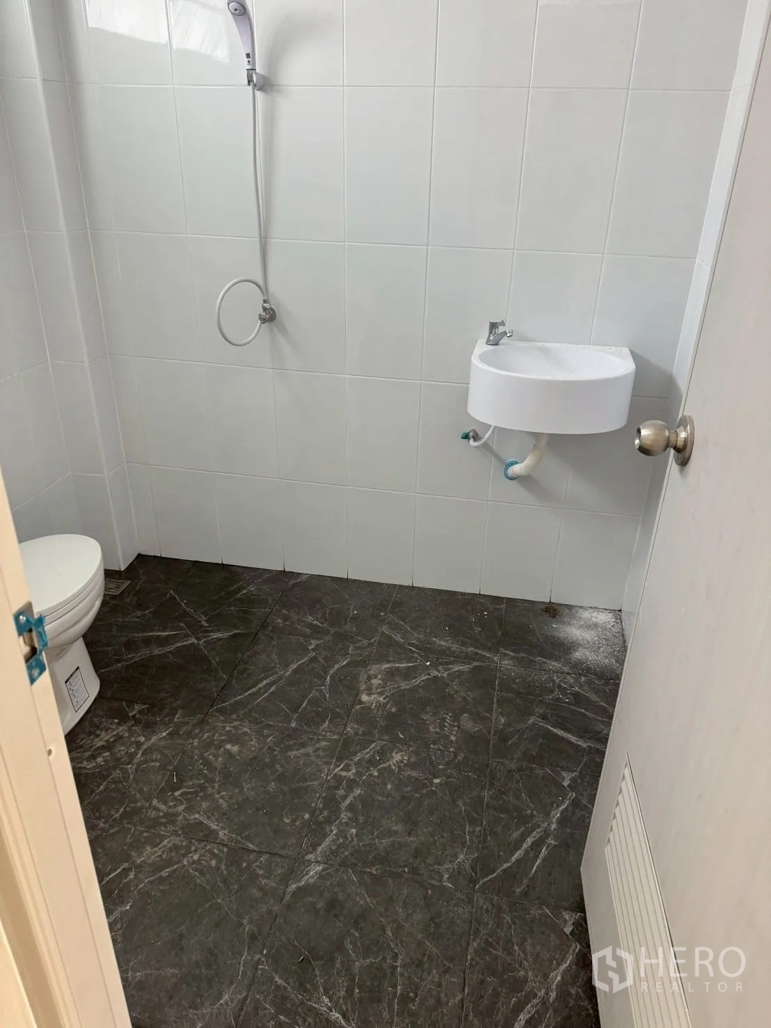 Warehouse for rent or sale in Nong Chok, Bangkok - Clean tiled restroom with shower, toilet and wall-mounted sink inside the warehouse.