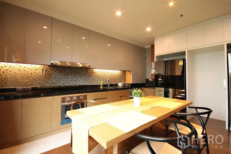 คอนโด ให้เช่าหรือขายในKhlong Toei, Bangkok - ครัวสมัยใหม่ตู้เงา โต๊ะทานอาหาร และไฟใต้ตู้