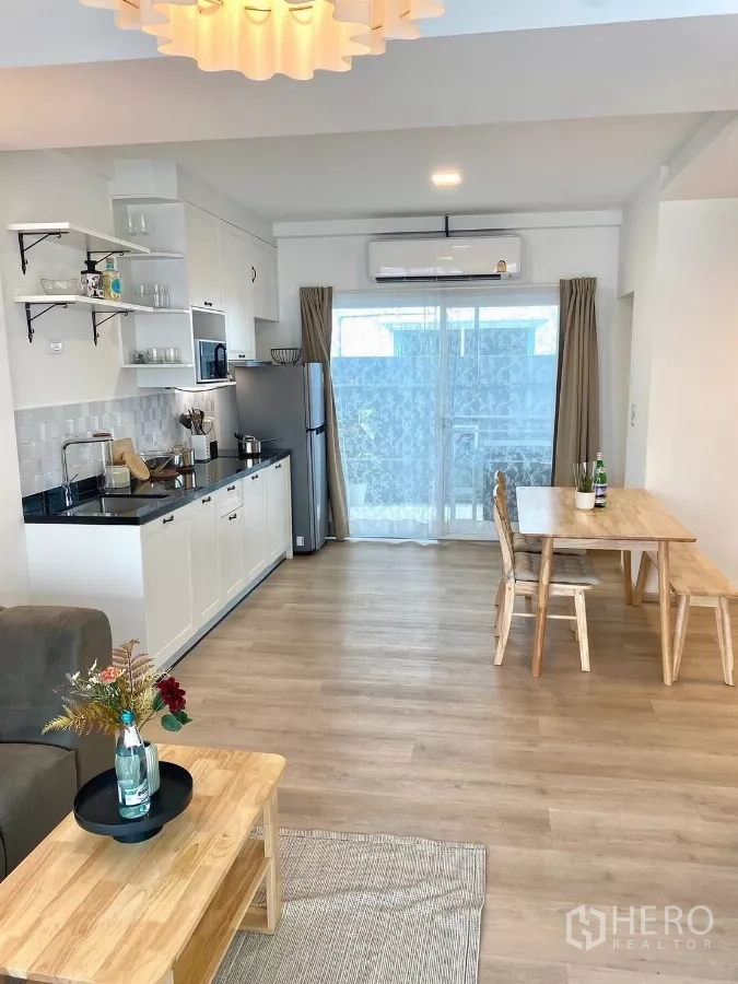 联排别墅 出租在Prawet, Bangkok - 开放式客餐厨空间，通向推拉玻璃门。