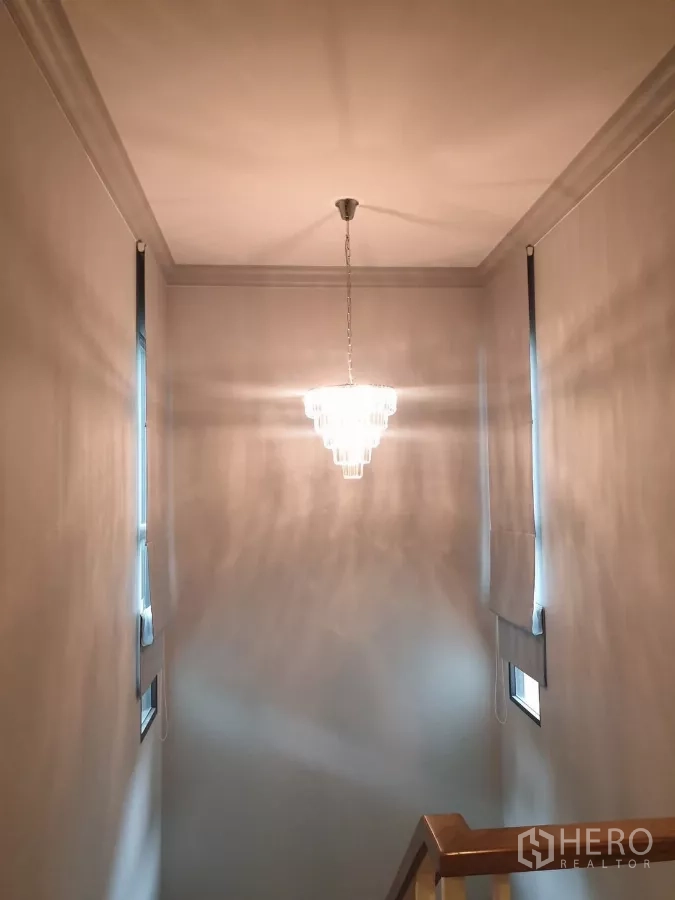 บ้าน ให้เช่าหรือขายในPrawet, Bangkok - โถงบันไดพร้อมโคมไฟระย้าและแสงธรรมชาติอ่อนๆ