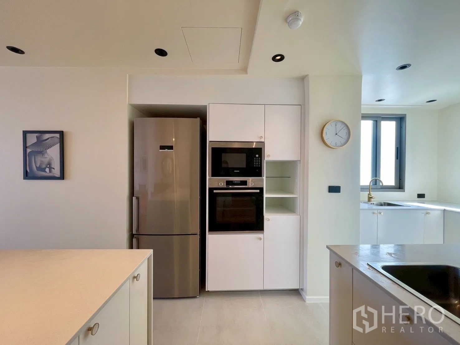 Condominium for sale in Watthana, Bangkok - Kitchen with built-in oven, microwave, and stainless refrigerator.