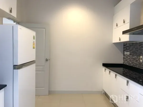 Detached House for rent or sale in Saphan Sung, Bangkok - Kitchen view showing refrigerator, ample counter space and storage cabinets.