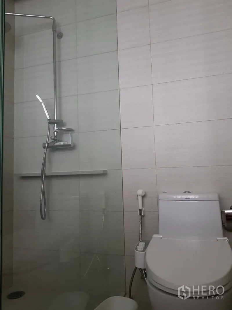 公寓 出租在Khlong Toei, Bangkok - 玻璃淋浴间与坐厕并列，浅色瓷砖墙面