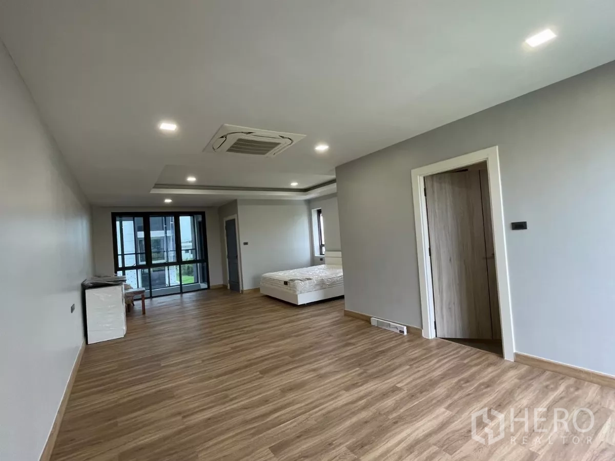 Home Office for rent in Khan Na Yao, Bangkok - Expansive bedroom with wood floor, cassette AC and sliding door to the balcony.