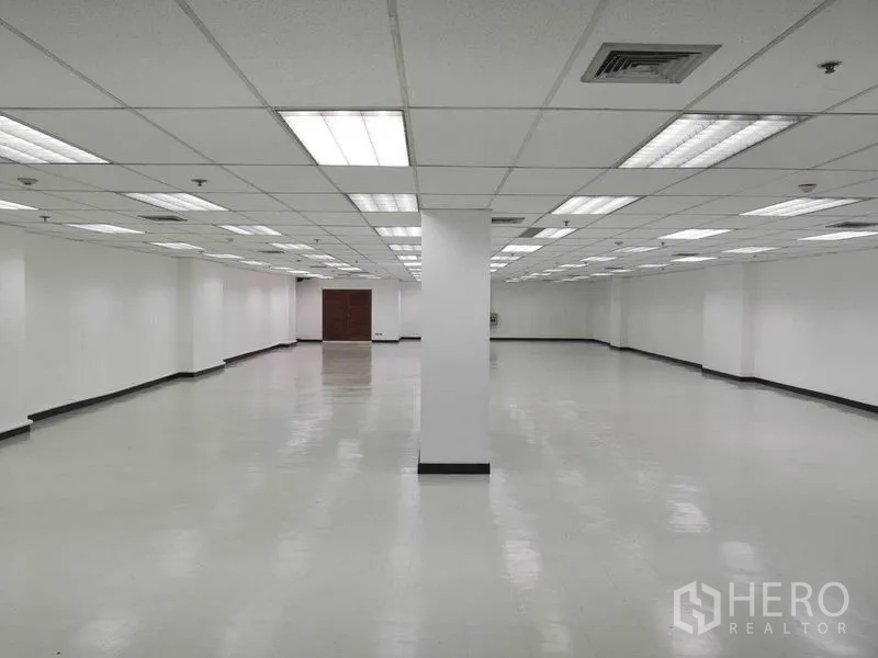 办公空间 出租在Phaya Thai, Bangkok - 办公室深处通向木门一侧，白墙与顶灯清晰可见。