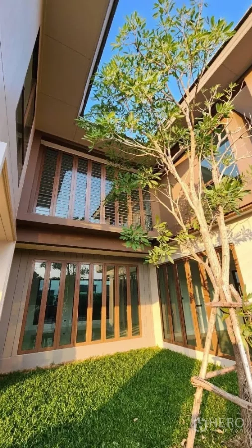 บ้าน ให้เช่าหรือขายในBang Kapi, Bangkok - ลานสนามหญ้าส่วนตัวมีต้นไม้ รายล้อมด้วยประตูกระจกสูงจรดเพดาน