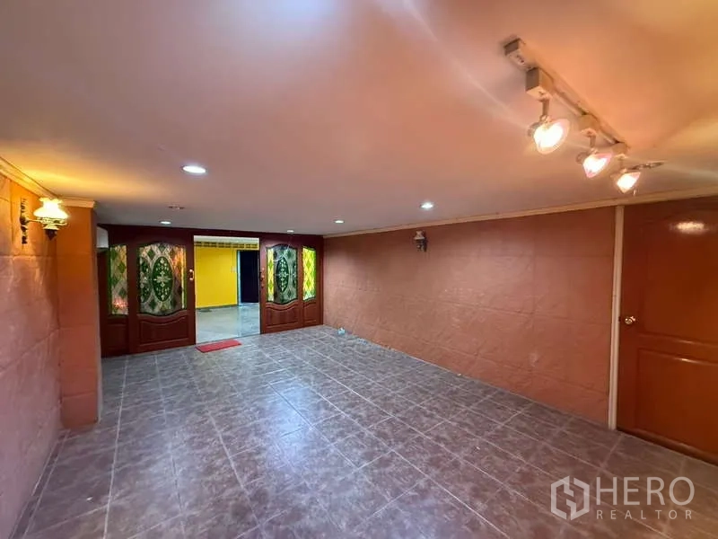 Home Office for rent in Khlong Toei, Bangkok - Tiled meeting or reception room with decorative stained-glass wooden doors and ceiling spotlights.