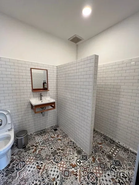 Townhouse for rent in Ratchathewi, Bangkok - Second bathroom with white subway-tile walls, patterned floor and open shower zone.
